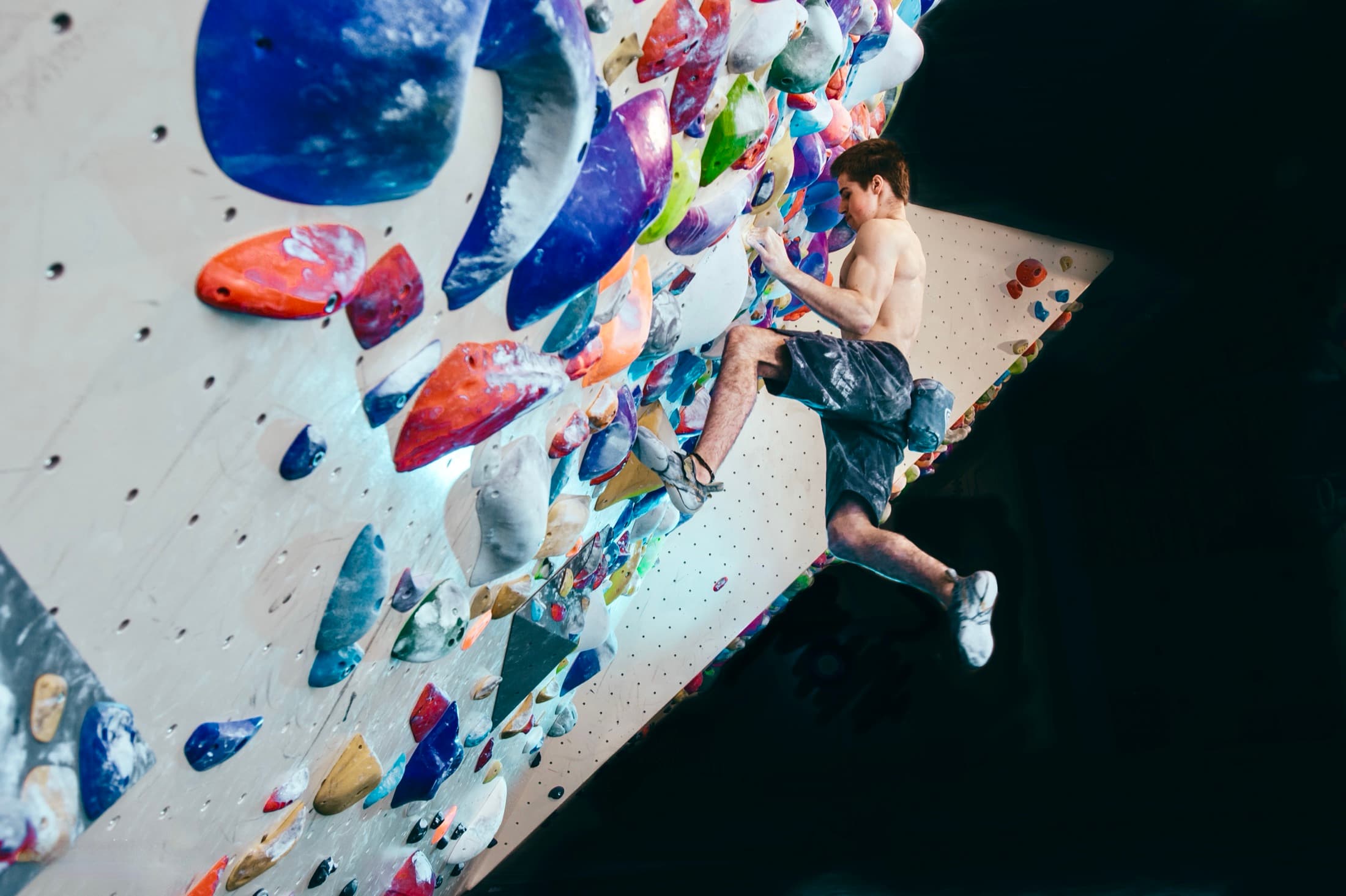 Bouldering a colourful volume-covered wall