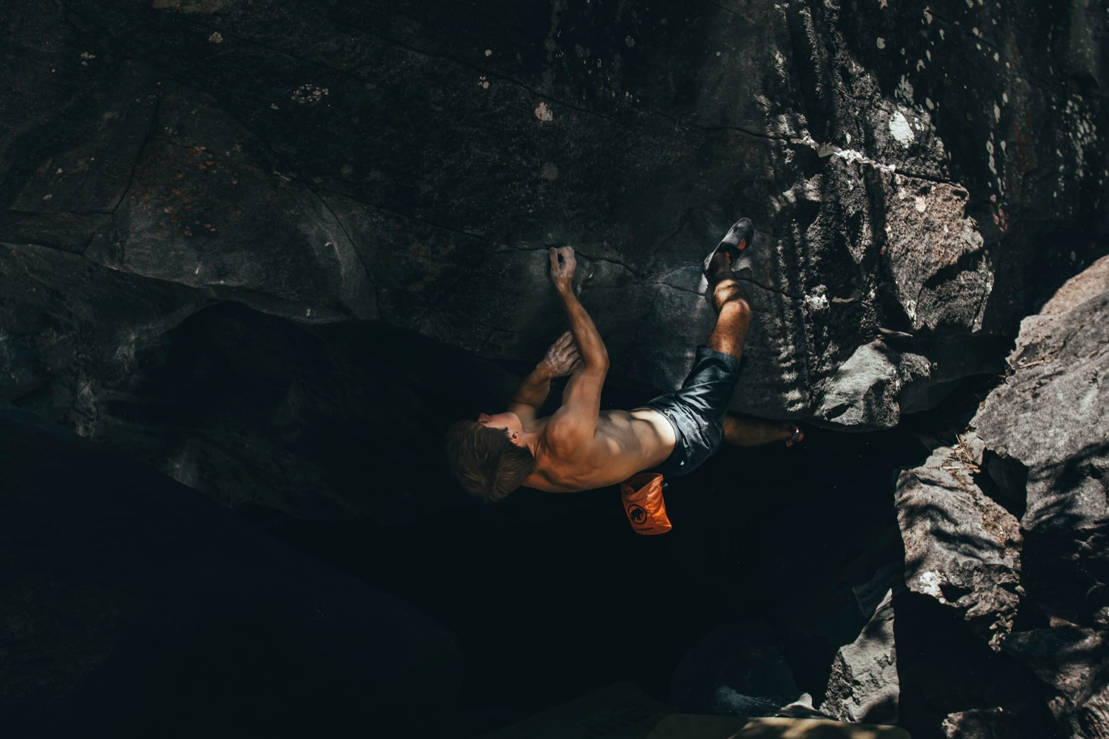 Bouldering in a dark cave-like overhang