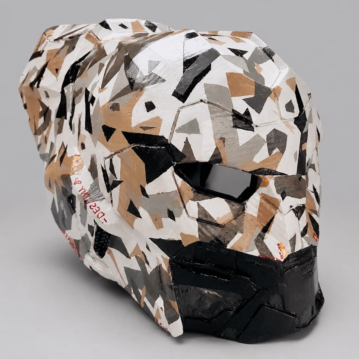 The finished helmet painted in hard-edged black, white and tan camouflage with a black lower jaw
