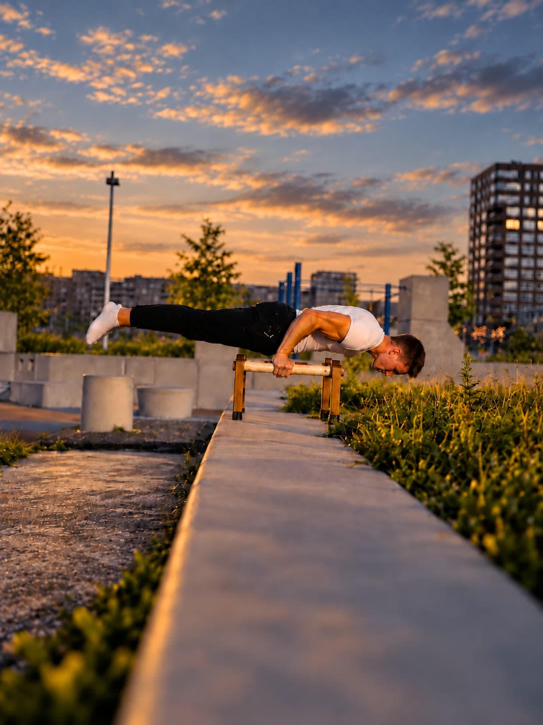Een horizontale hold op houten parallettes bij zonsondergang, lichaam recht en armen tot ongeveer negentig graden gebogen