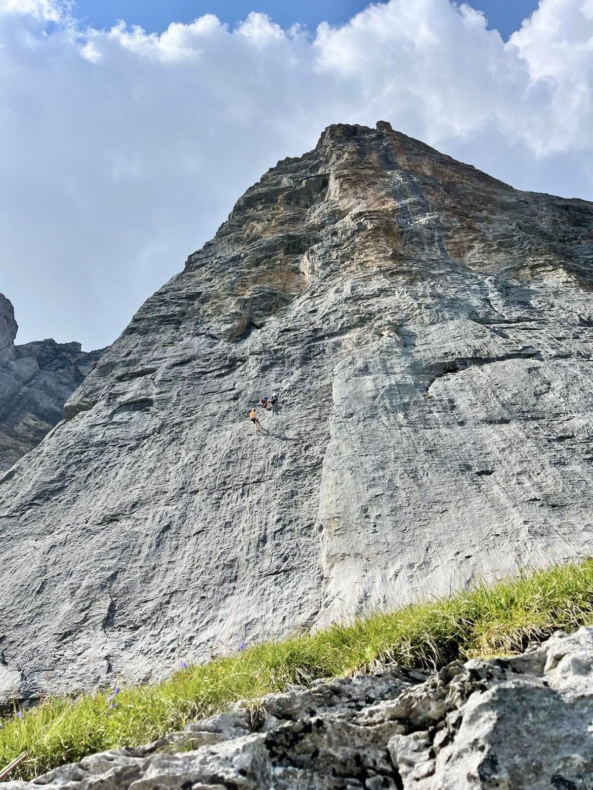The whole Wendenstöcke face seen from the ground, two climbers tiny against the middle of the wall